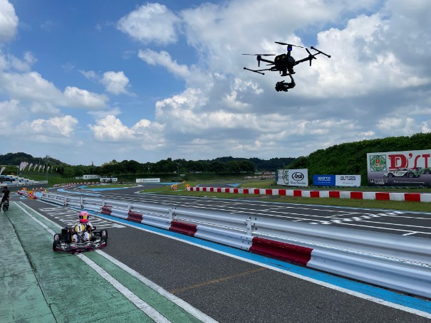 An Air-Peak drone is flying over the cart driver