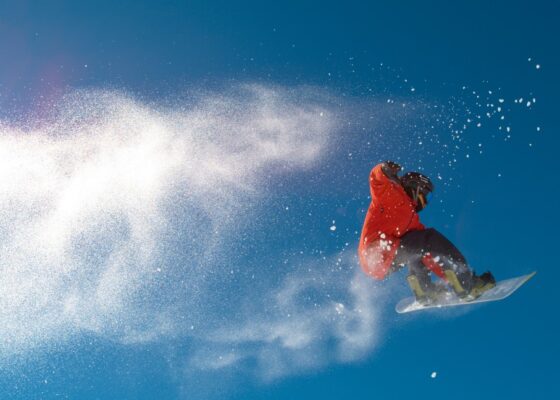 A Freestyle drone is capturing the snowboarder in the air