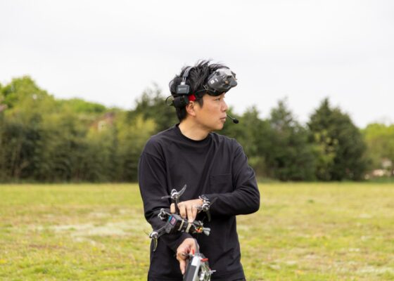 Kenji is wearing headgear and preparing to depart a drone